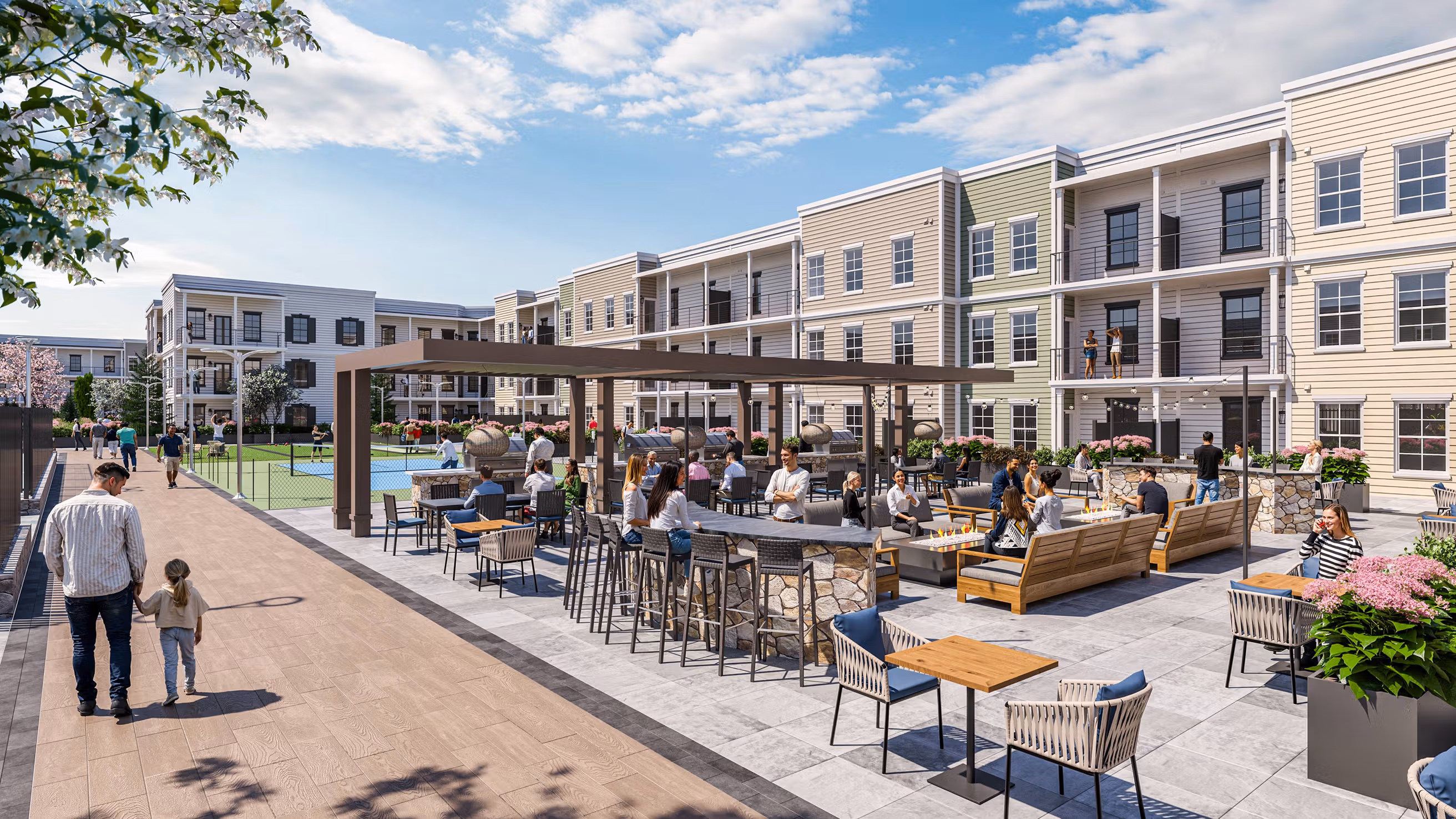 Outdoor lounge with fire pits, bar seating, and people socializing near modern apartment buildings.